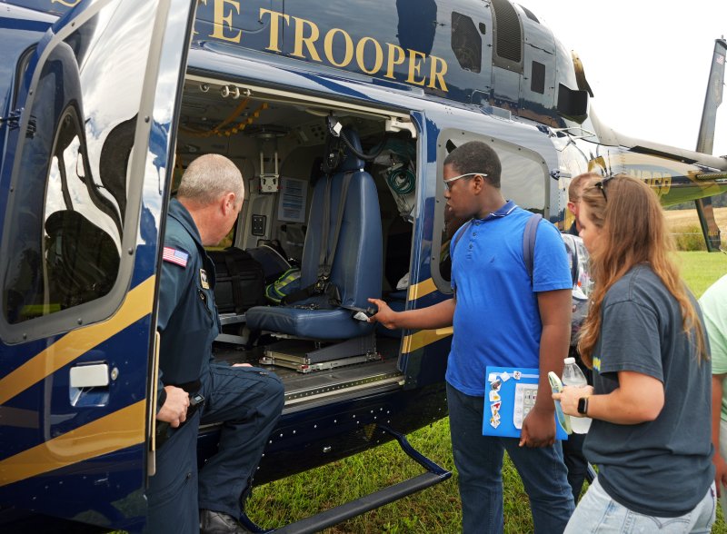 Delaware State Police Trooper Pilot Kevin Crossland, Cpl. 3, left, shows Sussex Consortium student Isaac Francois the inside of a DSP helicopter.